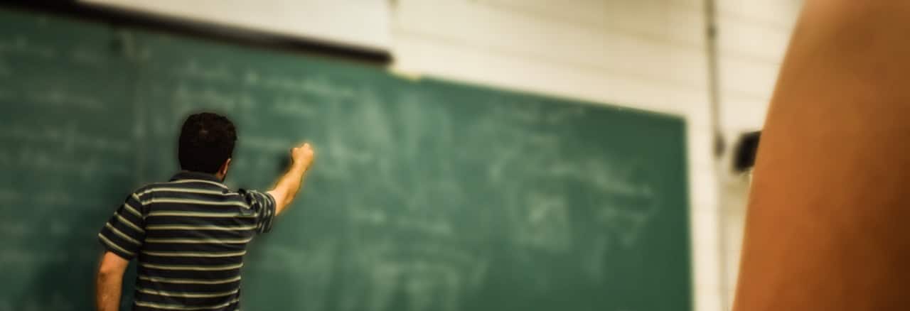 teacher writing on chalkboard